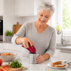 Senior woman using an electric can opener Senior woman using an electric can opener in a modern kitchen