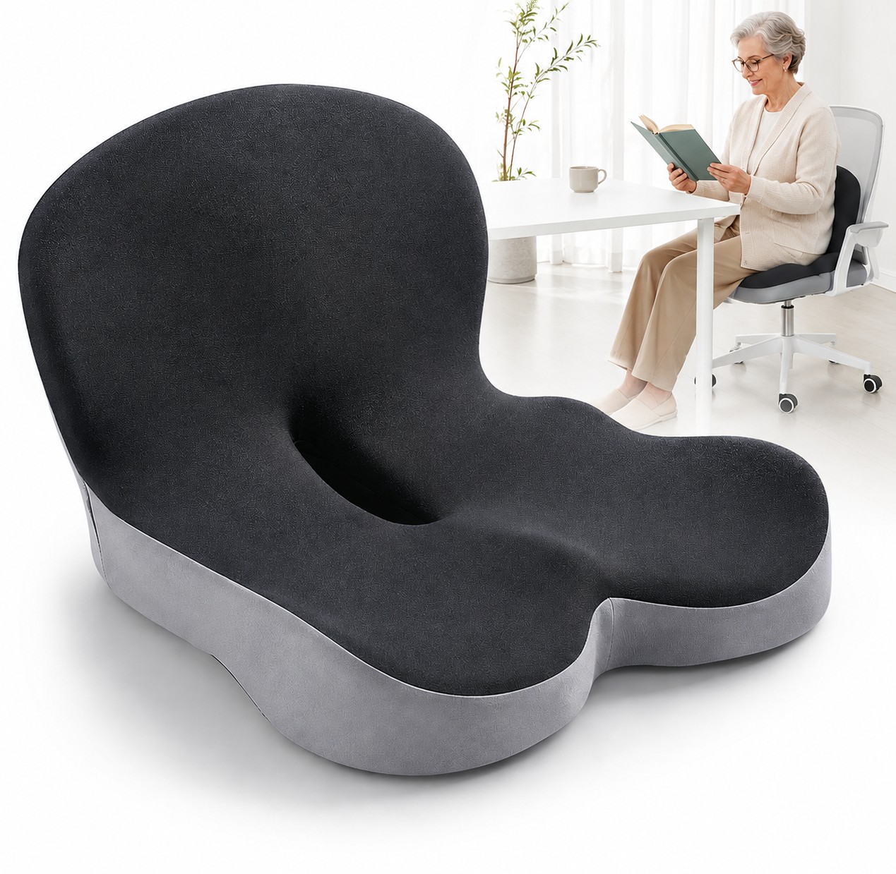 “Black ergonomic seat cushion with contoured support, shown beside an elderly woman comfortably seated and reading a book